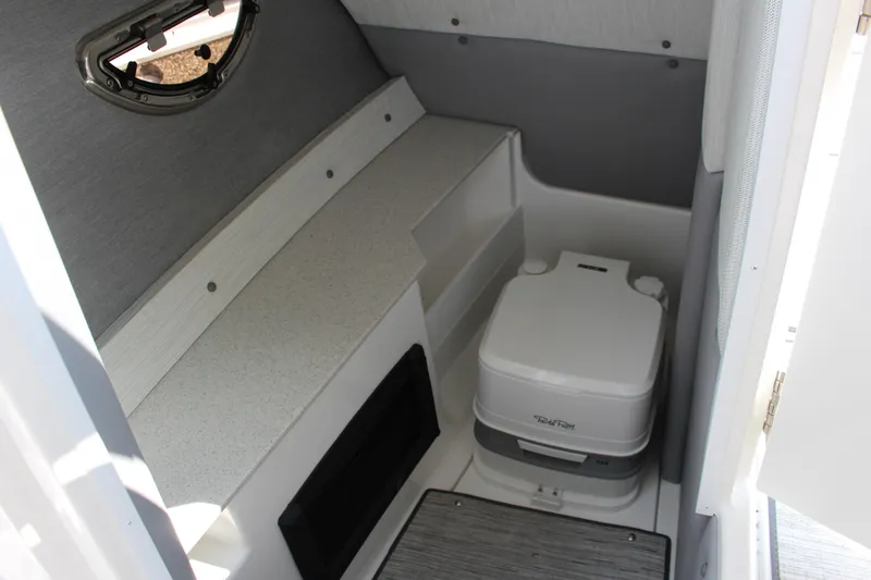 Slide: The Image of 2025 Cobalt R8 boat interior with compact portable toilet and storage space. - 6