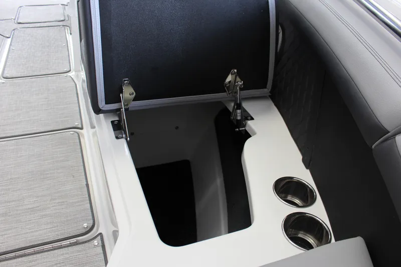 Slide: The Image of 2025 Cobalt R8 boat storage compartment with open lid and cup holders. - 12