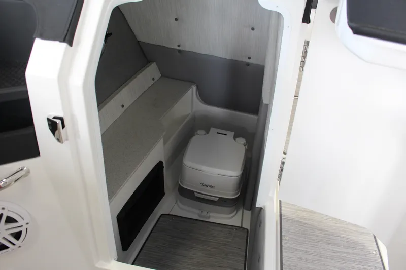 Slide: The Image of Compact interior of 2025 Cobalt R8 boat featuring a portable toilet. - 13