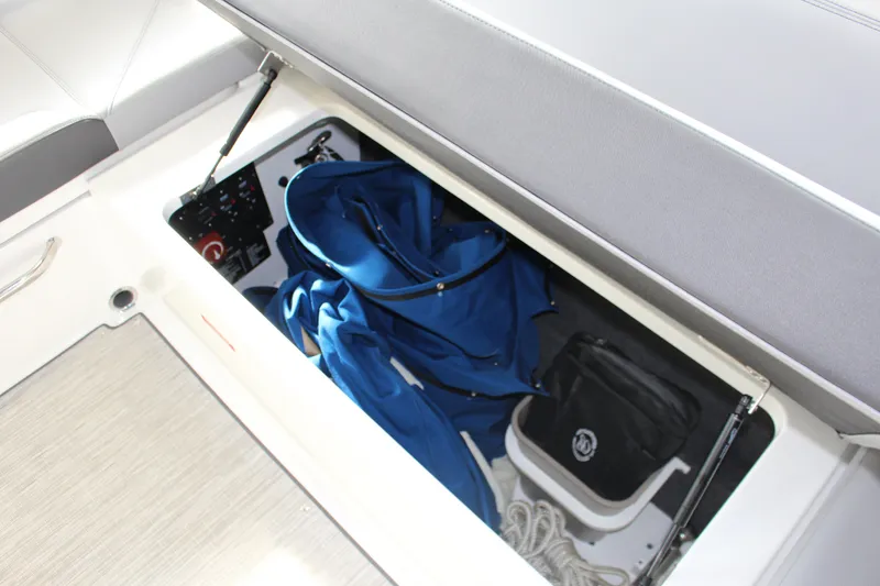 Slide: The Image of 2025 Cobalt R8 boat storage compartment with blue cover and accessories. - 22