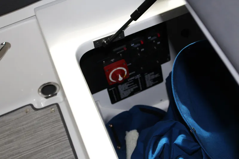 Slide: The Image of Storage compartment in 2025 Cobalt R8 boat with control panel and blue bag. - 23