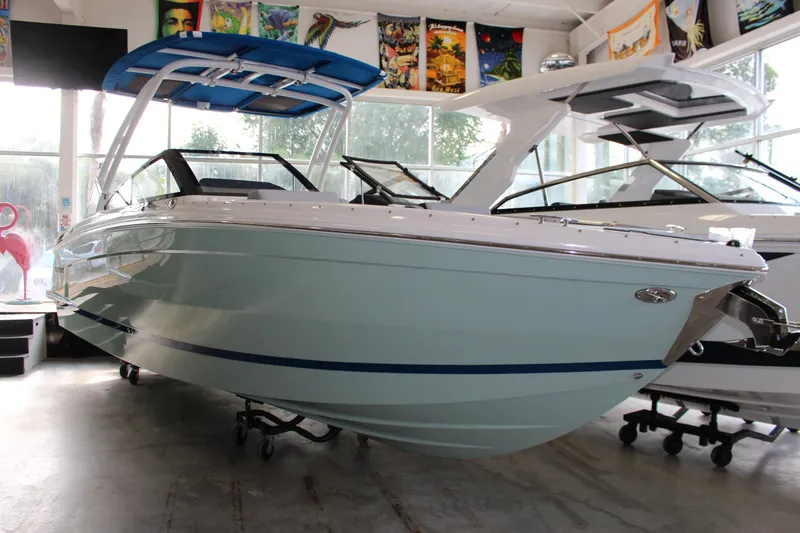 Slide: The Image of 2025 Cobalt R8 boat in showroom, featuring sleek design and blue accents. - 28