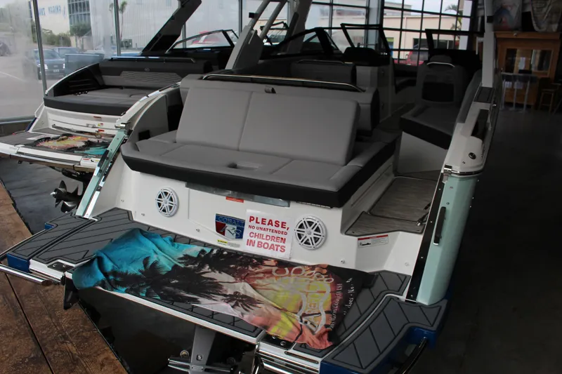 Slide: The Image of 2025 Cobalt R8 boat interior with seating and safety sign in showroom. - 33
