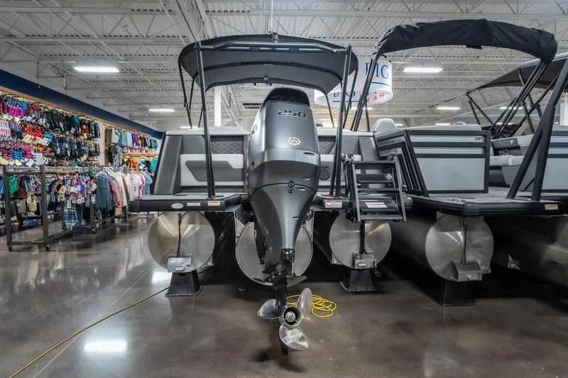 Slide: The Image of 2026 Viaggio D22U pontoon boat displayed in showroom with clothing racks in background. - 6