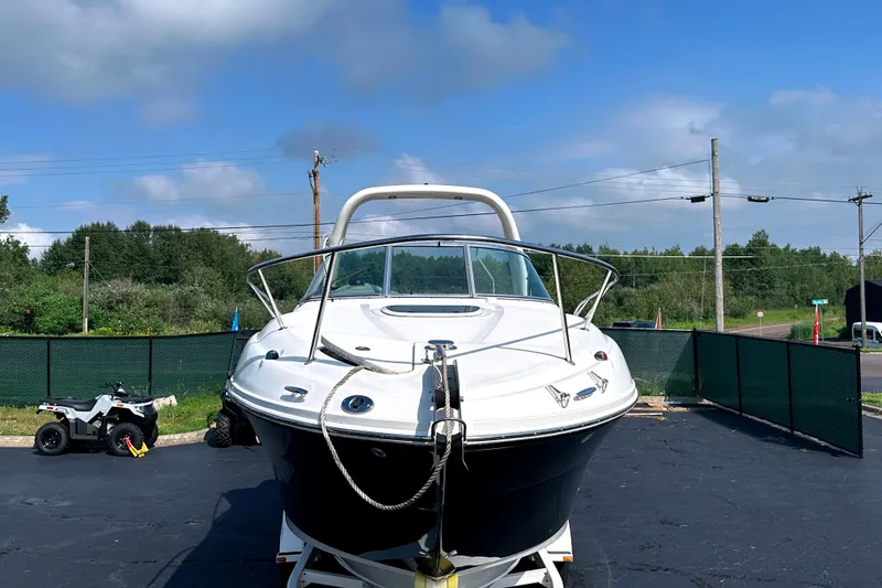 Slide: The Image of 2006 Sea Ray 260 Sundancer boat on trailer, parked outdoors under blue sky. - 11