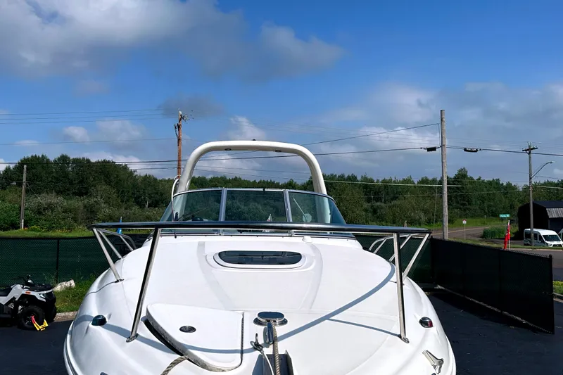 Slide: The Image of 2006 Sea Ray 260 Sundancer boat docked under a clear blue sky. - 12