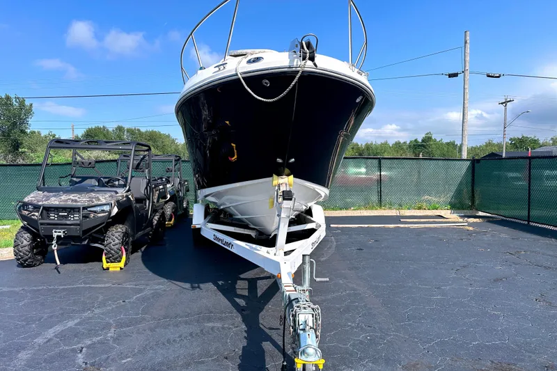 Slide: The Image of 2006 Sea Ray 260 Sundancer boat on trailer beside an off-road vehicle, parked outdoors. - 13
