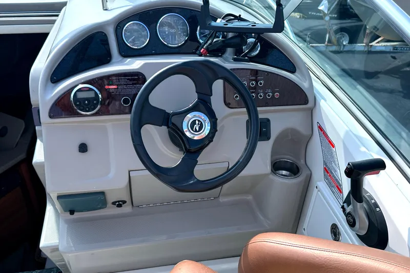 Slide: The Image of 2006 Sea Ray 260 Sundancer helm with steering wheel and control panel. - 18