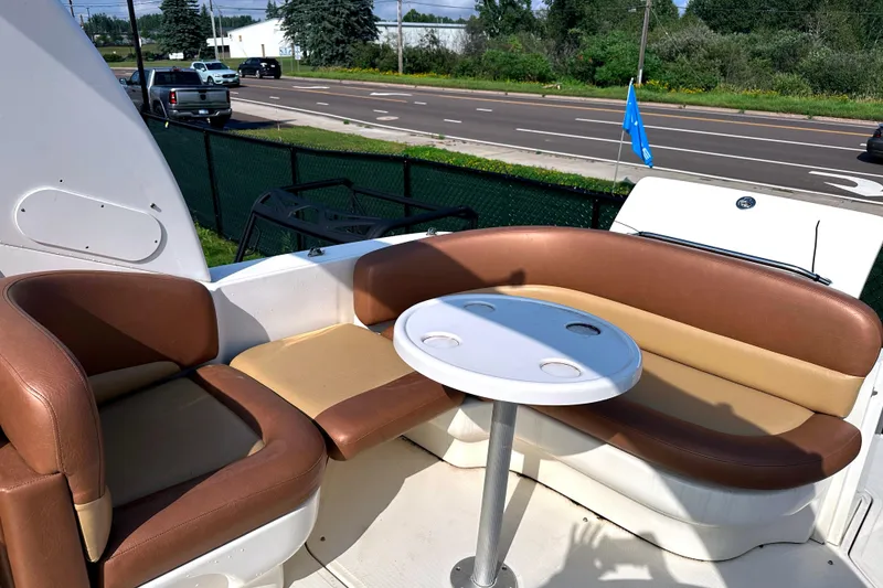 Slide: The Image of 2006 Sea Ray 260 Sundancer boat interior with brown seating and round table. - 19