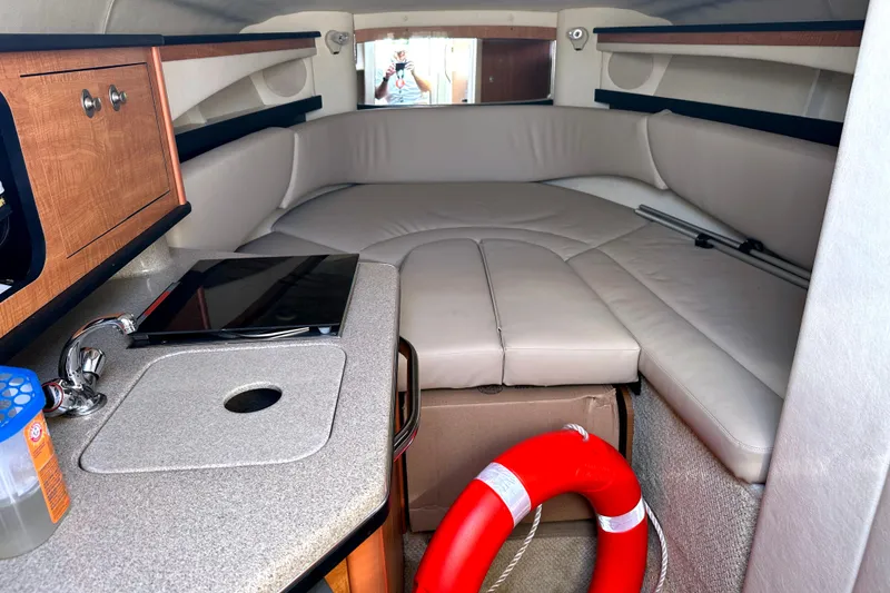 Slide: The Image of Interior of 2006 Sea Ray 260 Sundancer with beige seating and compact kitchenette. - 22