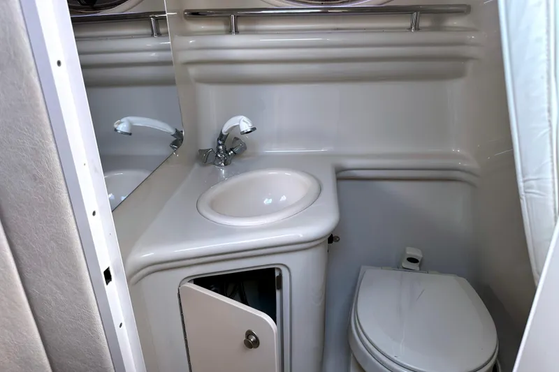 Slide: The Image of Compact bathroom in 2006 Sea Ray 260 Sundancer boat, featuring sink and toilet. - 25