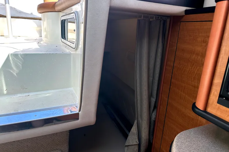 Slide: The Image of Interior view of a 2006 Sea Ray 260 Sundancer boat, featuring seating and cabin entrance. - 27
