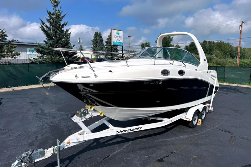 Slide: The Image of 2006 Sea Ray 260 Sundancer boat on trailer, parked outdoors under cloudy sky. - 5