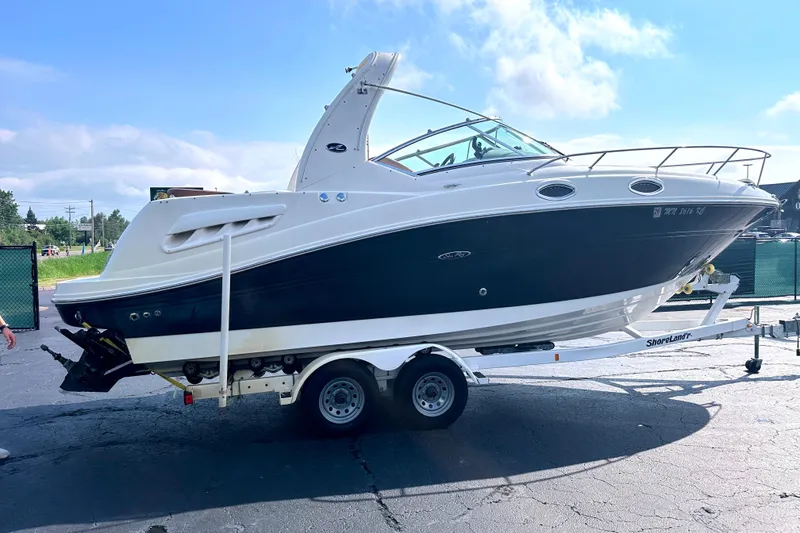 Slide: The Image of 2006 Sea Ray 260 Sundancer boat on trailer, parked outdoors under a clear sky. - 7