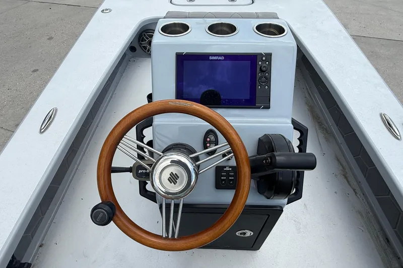 Slide: The Image of 2023 ZCB Curlew 18 boat console with wooden steering wheel and navigation display. - 12