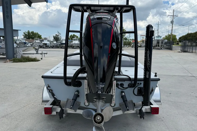 Slide: The Image of 2023 ZCB Curlew 18 boat with outboard motor, parked on a trailer in a marina. - 6