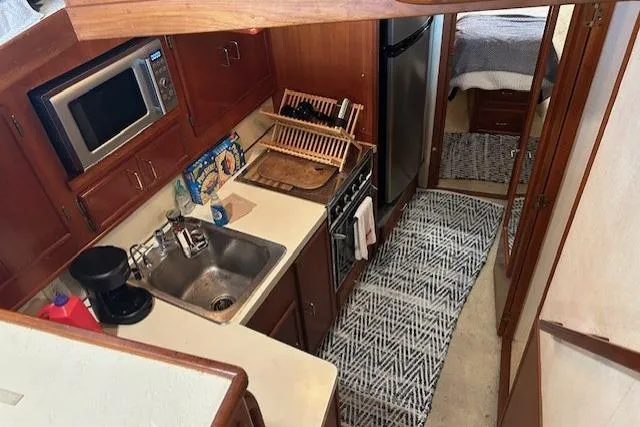 Slide: The Image of 1984 Post 43 Sport Fisherman yacht kitchen with sink, microwave, and stove. - 13