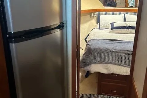 Slide: The Image of 1984 Post 43 Sport Fisherman interior with bed and refrigerator. - 15