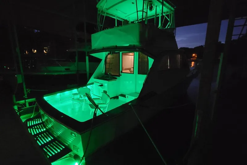 Slide: The Image of 1984 Post 43 Sport Fisherman yacht illuminated with green lights at night. - 2