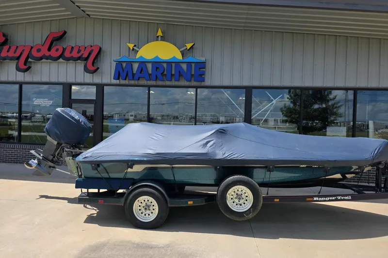 Slide: The Image of Covered 1994 Ranger 482 V boat on trailer outside marine store. - 11