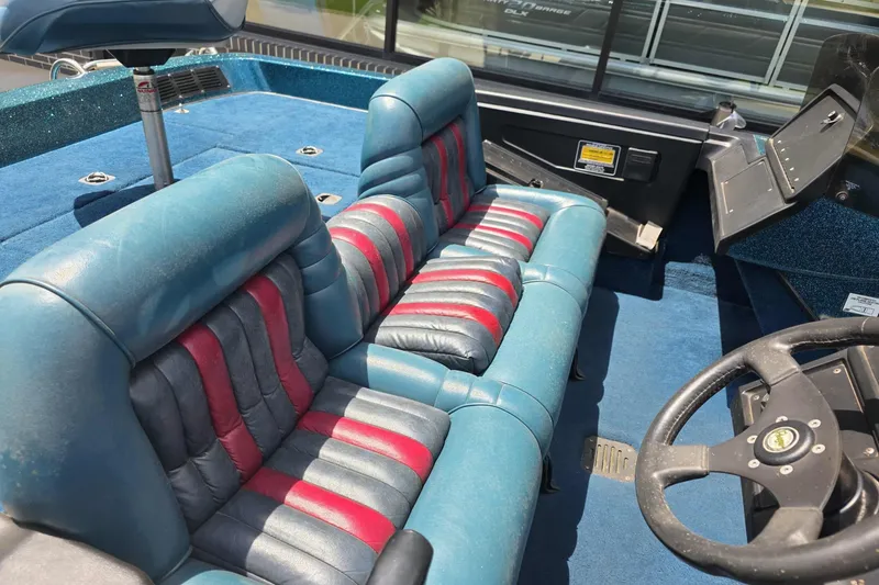 Slide: The Image of 1994 Ranger 482 V boat interior with blue and red seats, steering wheel, and dashboard. - 6