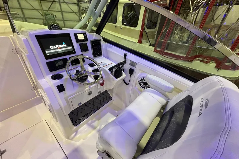 Slide: The Image of 2020 Cobia 280 Dual Console boat cockpit with Garmin display and comfortable seating. - 10
