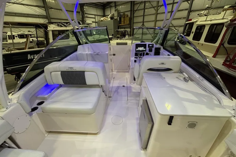 Slide: The Image of 2020 Cobia 280 Dual Console boat interior with seating and control panel in a showroom. - 15