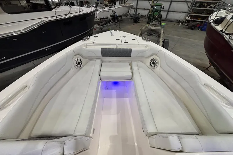 Slide: The Image of 2020 Cobia 280 Dual Console boat interior with white seating and blue LED lighting. - 17