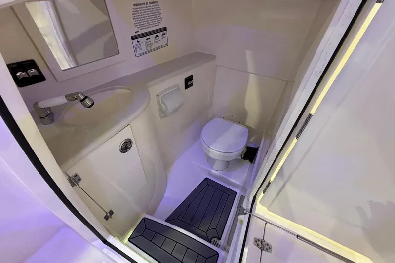 Slide: The Image of 2020 Cobia 280 Dual Console boat bathroom with sink, toilet, and mirror. - 19