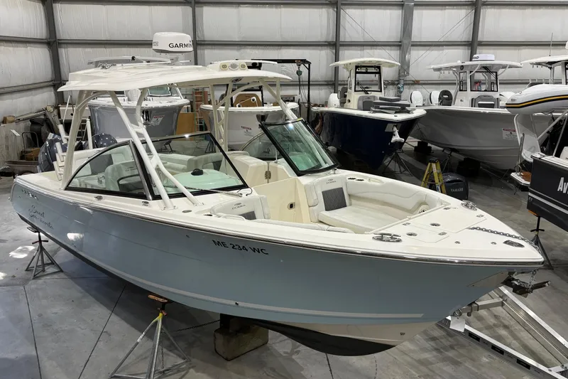 Slide: The Image of 2020 Cobia 280 Dual Console boat in indoor storage, featuring sleek design and spacious seating. - 2