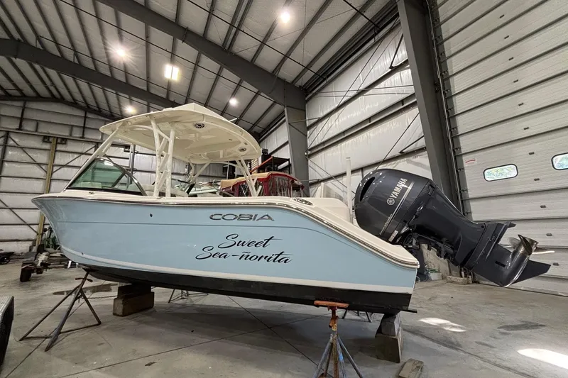 Slide: The Image of 2020 Cobia 280 Dual Console boat in a warehouse, featuring Yamaha outboard motor. - 3