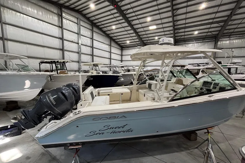 Slide: The Image of 2020 Cobia 280 Dual Console boat in storage, featuring Yamaha outboard engines. - 4