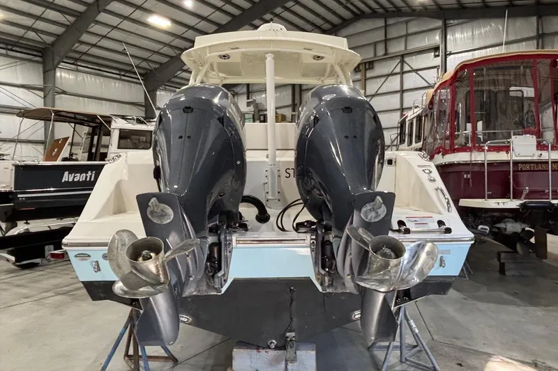 Slide: The Image of 2020 Cobia 280 Dual Console boat with twin outboard engines in a storage facility. - 5