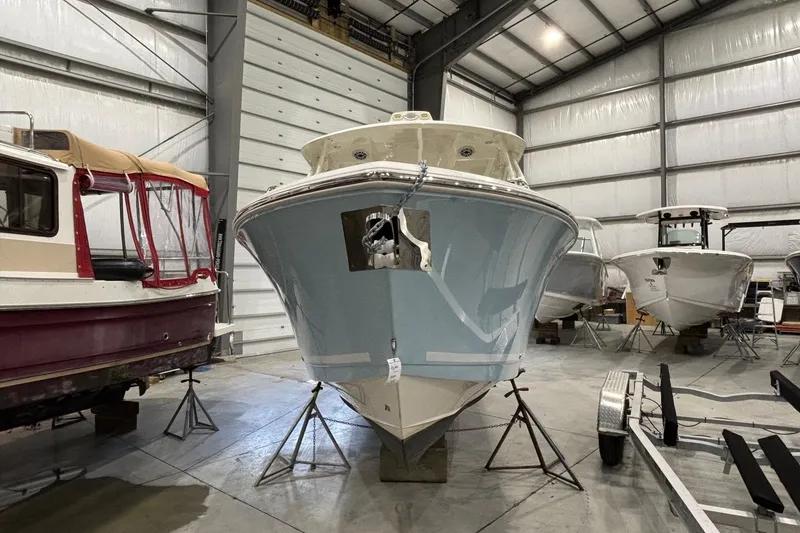 Slide: The Image of 2020 Cobia 280 Dual Console boat in storage, surrounded by other vessels. - 7