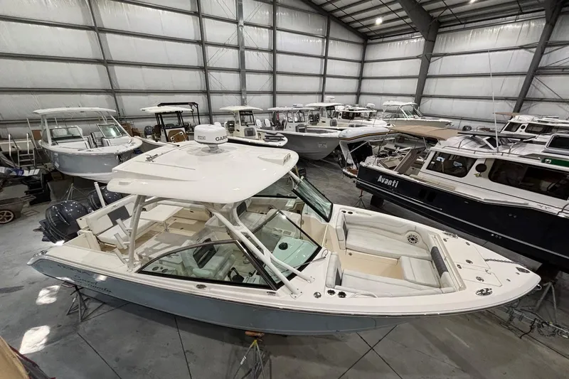 Slide: The Image of 2020 Cobia 280 Dual Console boat in indoor storage with other vessels. - 9