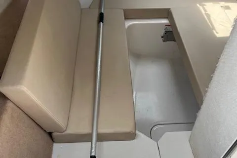 Slide: The Image of 2012 Chaparral 225 SSi boat interior with beige seating and storage compartment. - 11