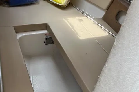 Slide: The Image of 2012 Chaparral 225 SSi boat interior with beige seating and storage compartment. - 12