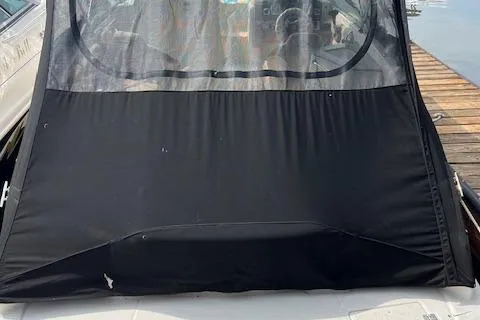 Slide: The Image of 2012 Chaparral 225 SSi boat with black cover docked by the water. - 4