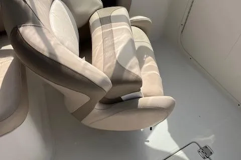 Slide: The Image of 2012 Chaparral 225 SSi boat interior with beige seating and sunlight shadows. - 7