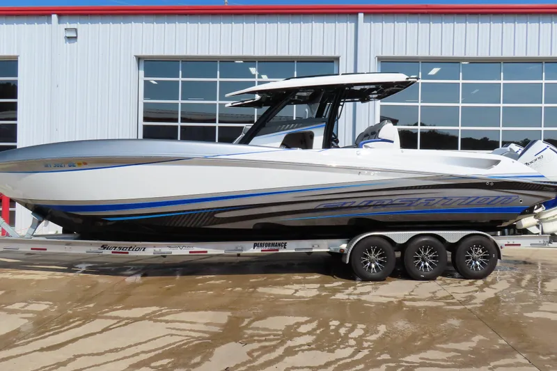The Image of 2021 Sunsation 34 CCX boat on trailer, parked outside a building. - 1