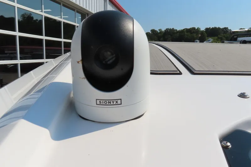 Slide: The Image of SIONYX camera on 2021 Sunsation 34 CCX boat deck, near a modern building. - 11
