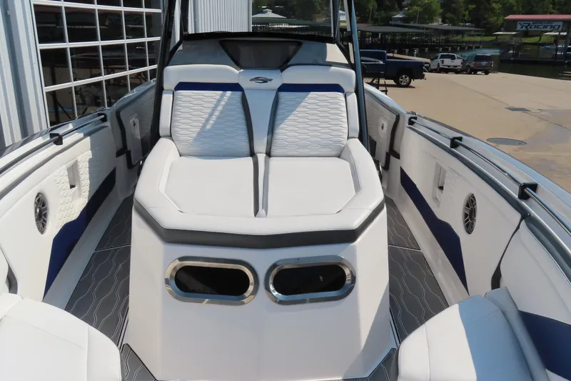 Slide: The Image of 2021 Sunsation 34 CCX boat interior with white and blue seating, docked outdoors. - 16