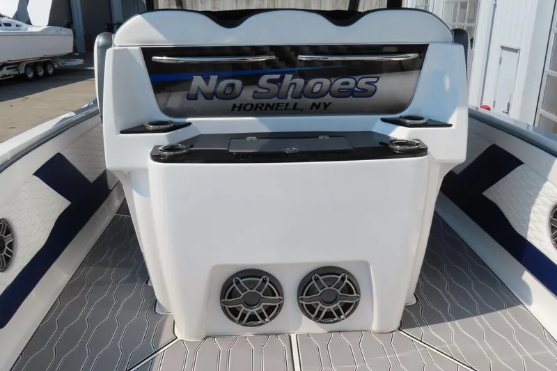 Slide: The Image of 2021 Sunsation 34 CCX boat interior with "No Shoes" sign, cup holders, and speakers. - 19