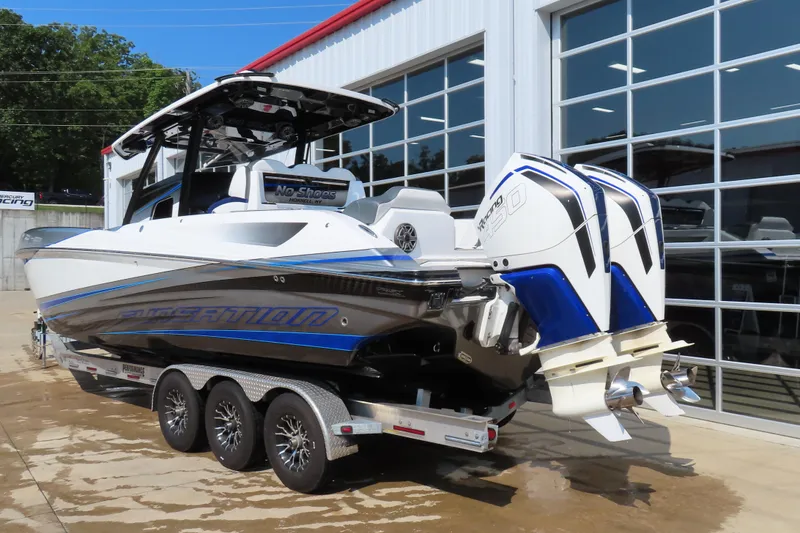 Slide: The Image of 2021 Sunsation 34 CCX boat with dual engines on a trailer outside a garage. - 4