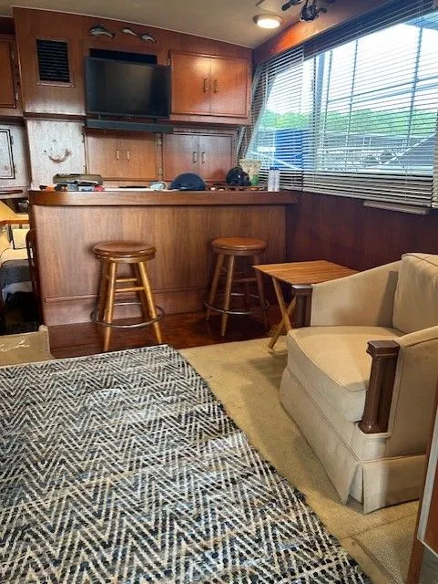 Slide: The Image of Interior of 1984 Post 43 Sport Fisherman with wood cabinetry, bar stools, and patterned rug. - 10