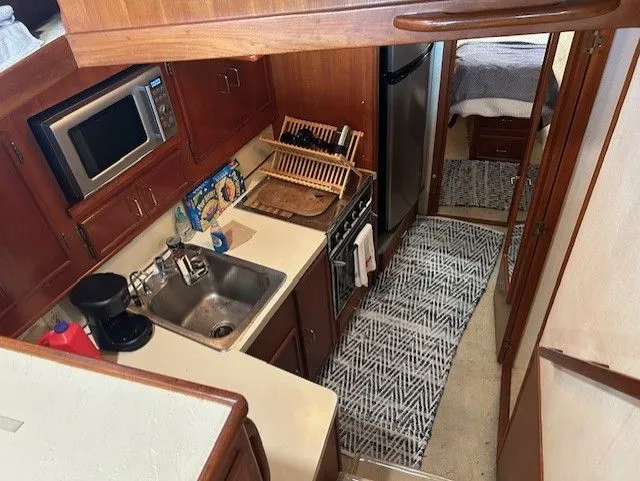 Slide: The Image of 1984 Post 43 Sport Fisherman yacht kitchen with sink, microwave, and stove. - 12