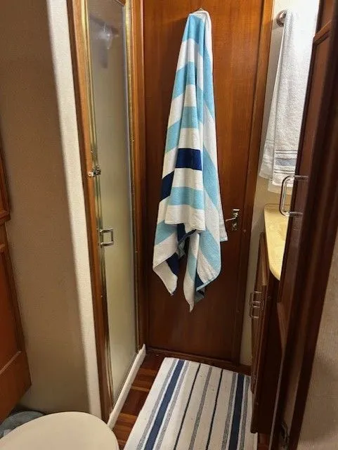 Slide: The Image of 1984 Post 43 Sport Fisherman bathroom with striped towel and shower. - 16