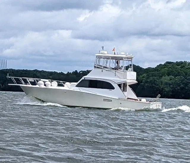 The Image of 1984 Post 43 Sport Fisherman boat cruising on a lake under cloudy skies. - 0