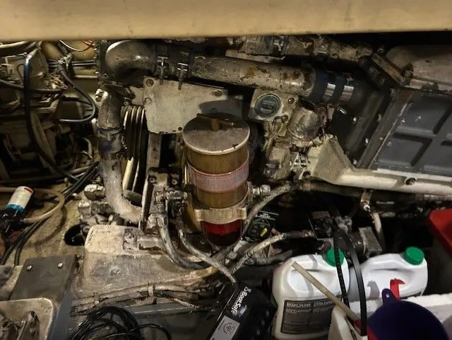 Slide: The Image of Engine compartment of a 1984 Post 43 Sport Fisherman boat, showing mechanical components and fluid containers. - 19