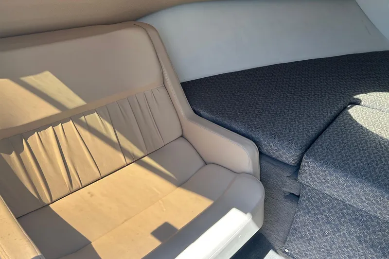 Slide: The Image of Interior of a 2001 Cobalt 227 boat, featuring beige seating and patterned upholstery. - 10